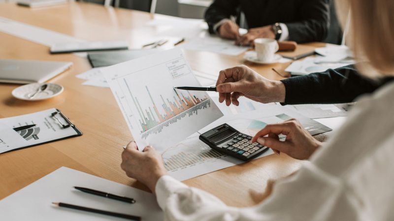 Professionals reviewing financial graphs and charts during a meeting. — Experience Professional Care at Home with Massage Lon