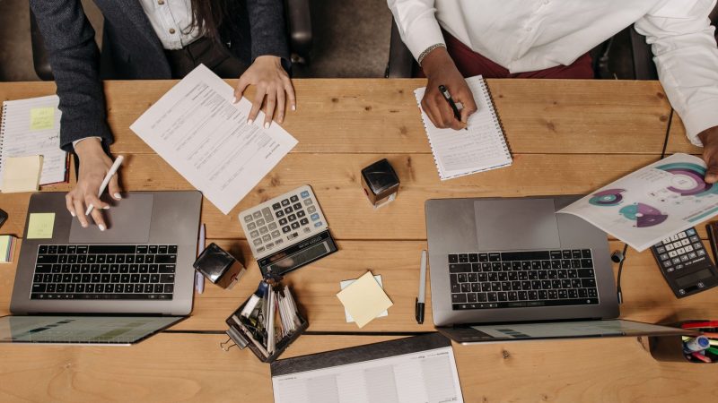 High-angle view of professionals working collaboratively with laptops and documents in an office. — Fluoride-Free Toothpaste: