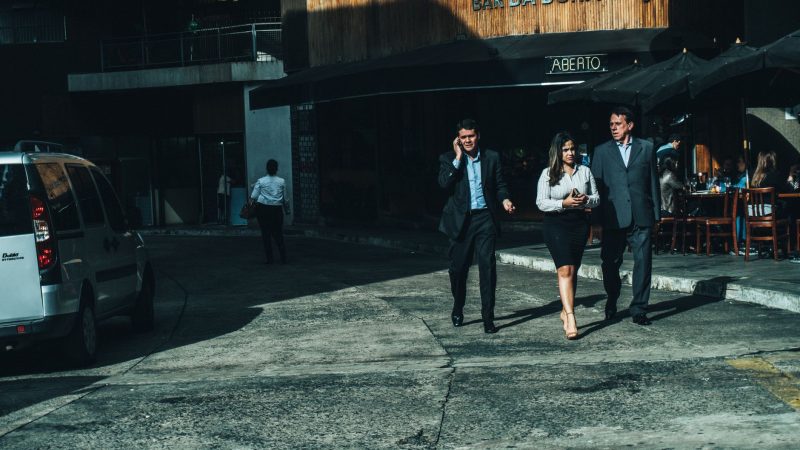 Three business professionals walk along a city street outside a cafe. — Never Miss a Lap With Formel1 Coverage on IPTV Platfo